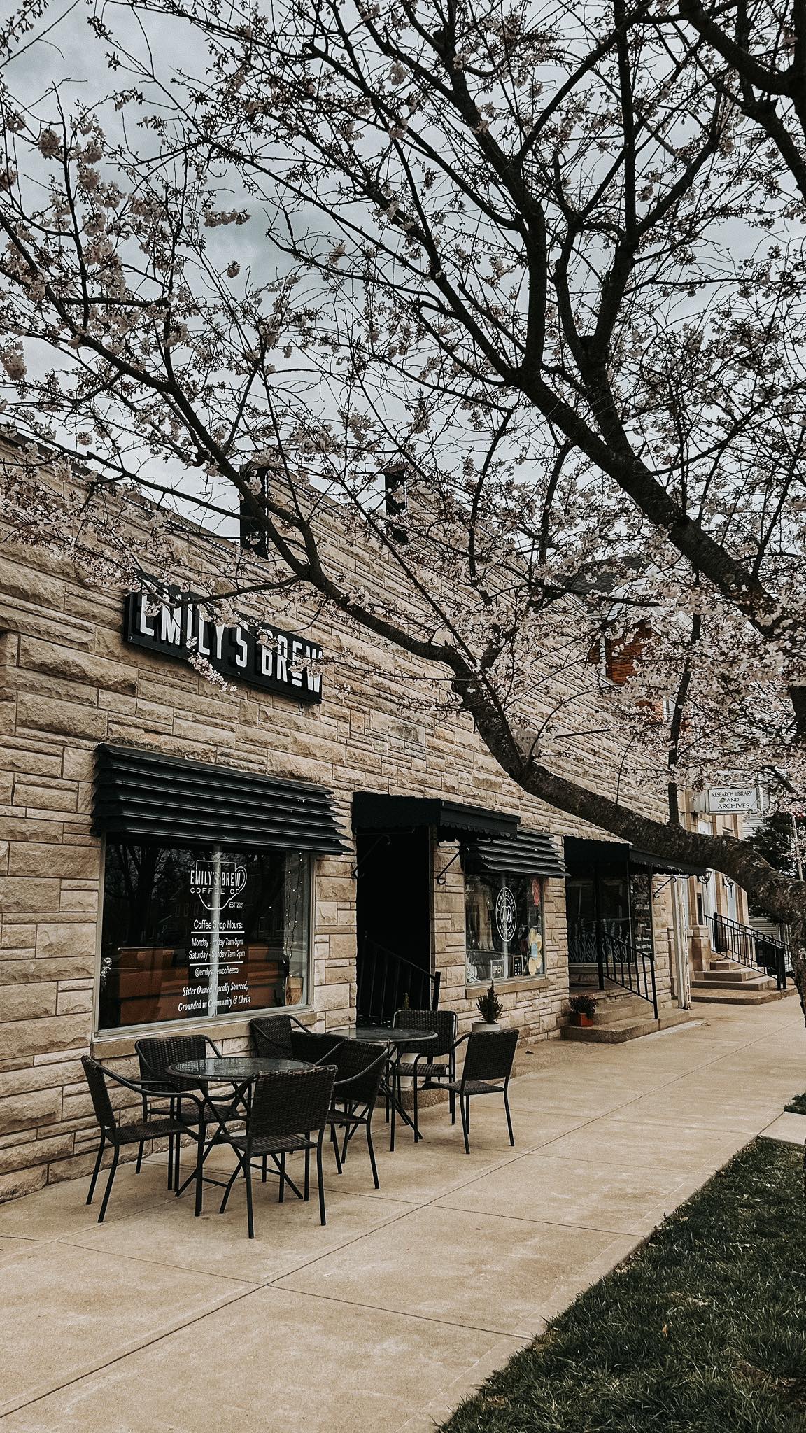 The Emily’s Brew storefront on the Versailles square under blooming trees
