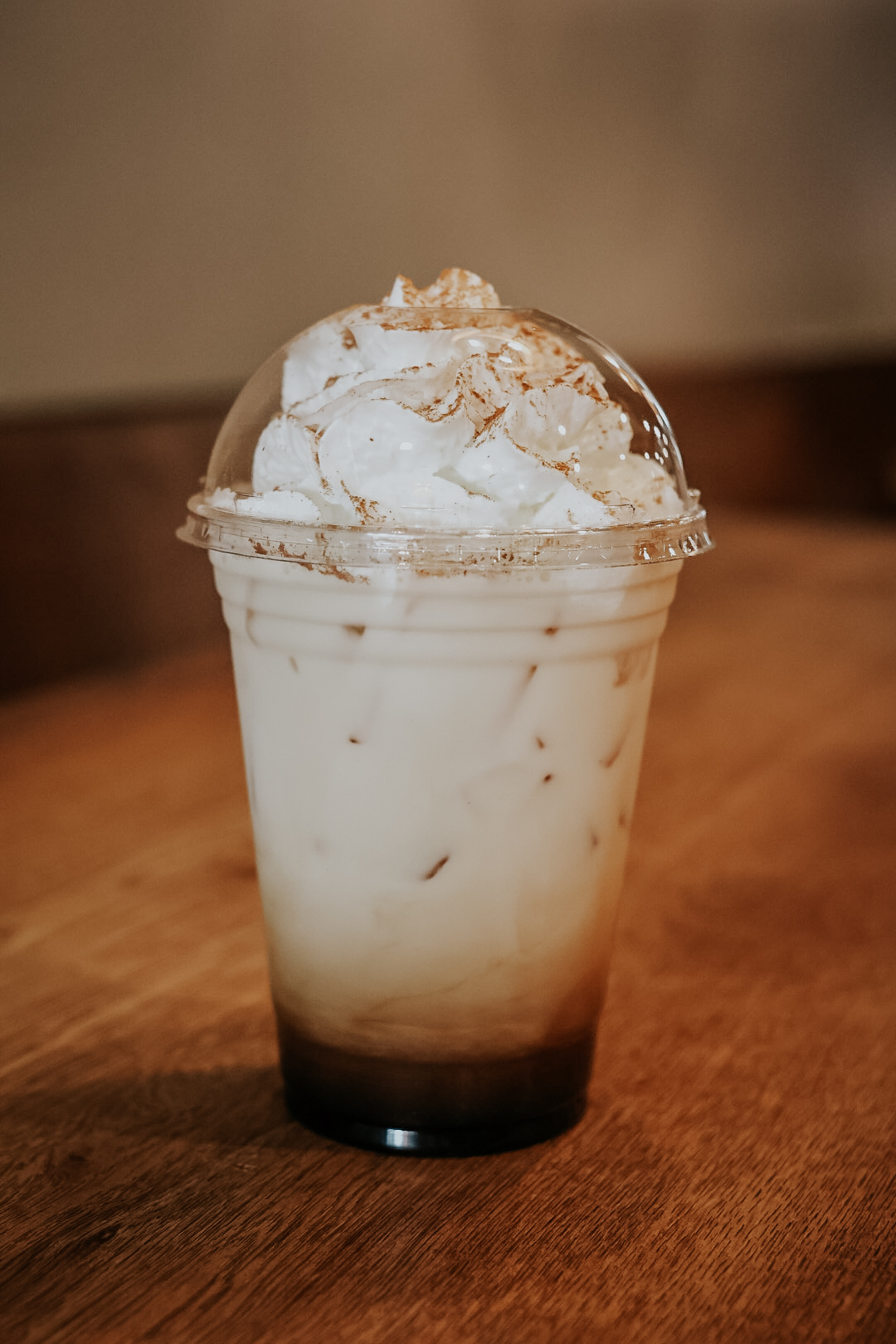 Iced chai topped with whipped cream and cinnamon